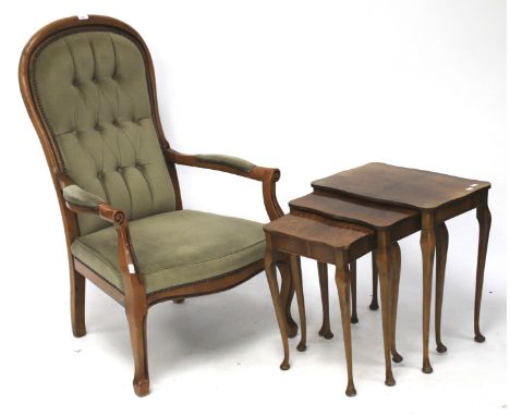 A 20th century elbow chair and a nest of three veneered tables. The chair with a wooden frame and upholstered in green with a