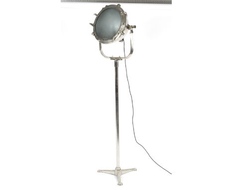 A retro chrome spotlight on stand. The large adjustable lamp on tubular base and tripod stand, electrified, 189cm high 