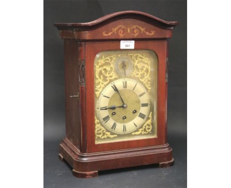 A 20th century bracket clock. The gilt dial with Roman numerals denoting hours, the wooden case with carved and applied detai