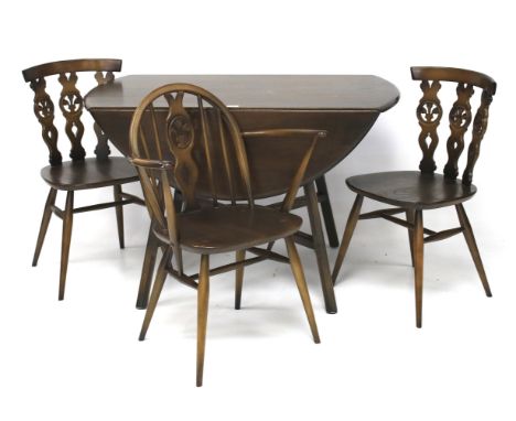 A dark stained oak Ercol dining table and three chairs. The Sutherland table of oval form with crossed stretchers, L115cm x D