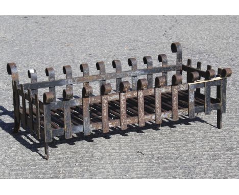A cast iron fire grate. Of rectangular section, with scroll finials, 75cm long