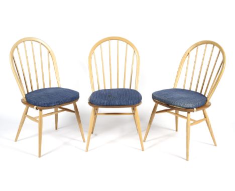 A set of three blonde Ercol dining chairs. With spindle backs, each with Ercol mark to underside, each measuring approximatel