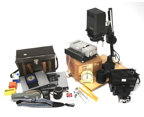 A collection of photographic equipment, including a Leitz/Leica slide projector, a Meopta axomat 5 enlarger with 50mm lens an