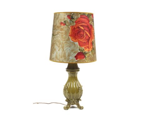 A mid-century Italian pottery table lamp. Decorated with a green glaze, raised upon scrolling supports, with large lamp shade