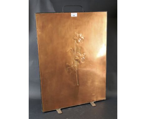 A 20th century Copper firescreen. With hammered decoration depicting a daffodil and single metal handle to top, L46cm x H65cm