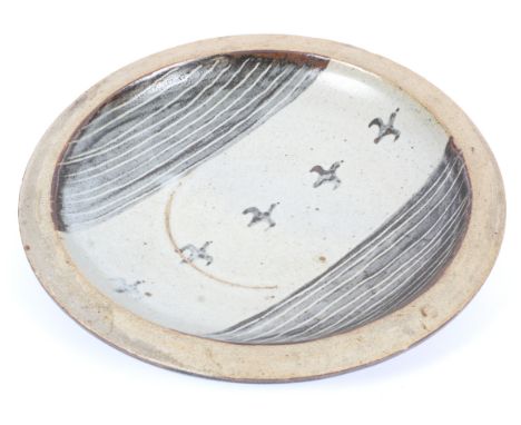 A Bernard Leach (1887-1979) Studio pottery dish. Decorated with a seascape, sea gulls flying above the sea, painted BL to rev