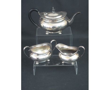 GEORGE V SILVER THREE PIECE OVAL TEA SET raised on bun feet comprising tea pot, cream jug and two handled sucrier.  Sheffield