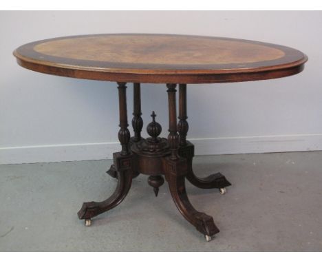 VICTORIAN CROSS BANDED OVAL WALNUT LOO TABLE, the top with quarter veneers, on a four column base with centre circular boss h