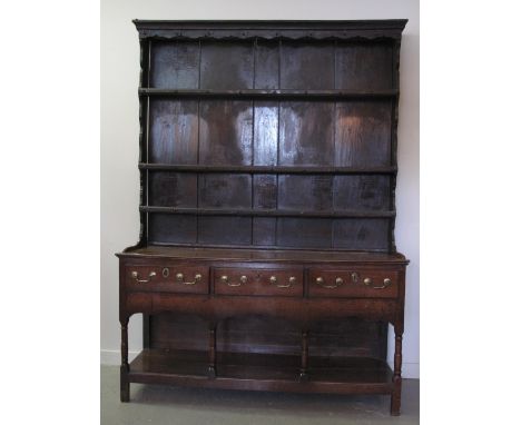 EARLY 19th CENTURY WELSH OAK POT BOARD DRESSER having stained three shelf boarded rack back.  The base with three moulded edg