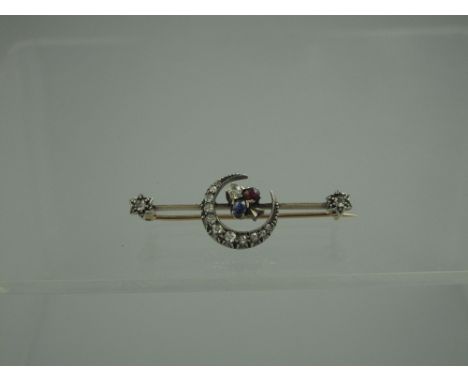 A VICTORIAN DIAMOND, SAPPHIRE AND RUBY CRESCENT BAR BROOCH.  The central crescent set with eleven graduated old cut diamonds 