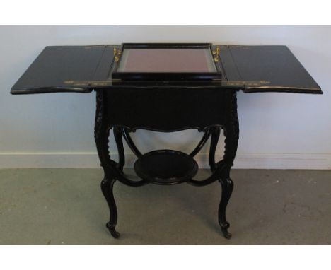 LATE VICTORIAN EBONIZED BARKERS PATENT SERPENTINE SHAPED OPENING COCKTAIL TABLE with lift out tray and gilt brass fittings, s