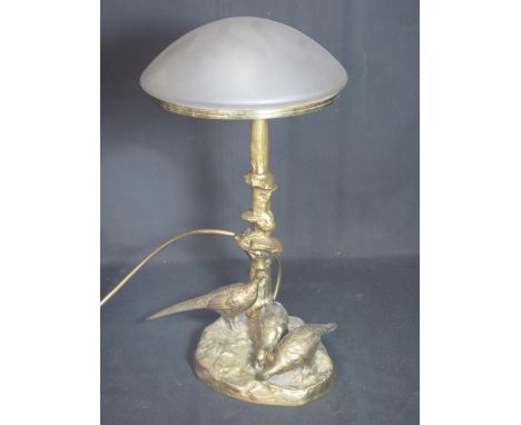 A YELLOW METAL SCULPTURAL LAMP BASE with frosted domed glass shade with arboreal column, the naturalistic base set with three