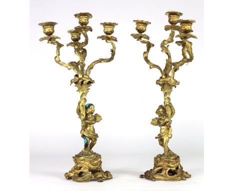 A pair of 19th Century gilt metal and ormolu four light Candelabra, with leaf moulded decoration, supported by winged cupids,