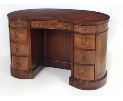 An attractive Edwardian kidney shaped Writing Desk, the top with tooled gilt decorated leather inset over a frieze with three