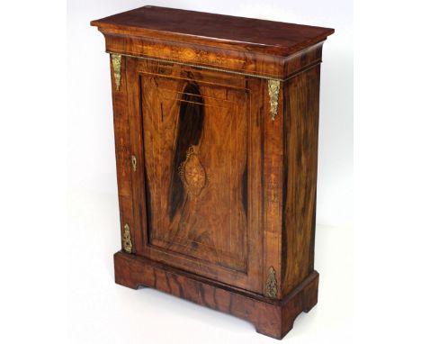 A Victorian walnut Side or Pier Cabinet, the plain top over an inlaid and shaped frieze, and panel door with ormolu mounts, o