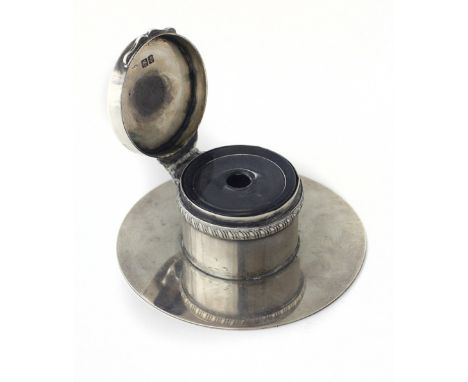 An Edwardian silver desk Inkwell, on circular base with hinged lid, with glass liner, strongly and simply made, from a Regent