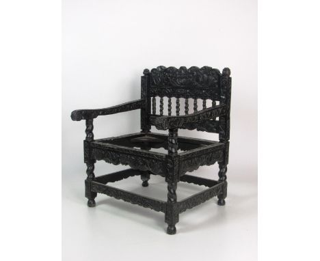 An important 18th Century Indo-Dutch ebony Armchair, of small scale with elaborately carved overall decoration, the back rail