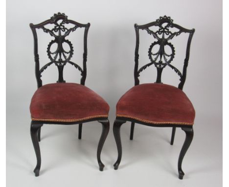 A pair of Edwardian ebonised Adams style Side Chairs, with decorative pierced and carved backs, covered in pink draylon, on f