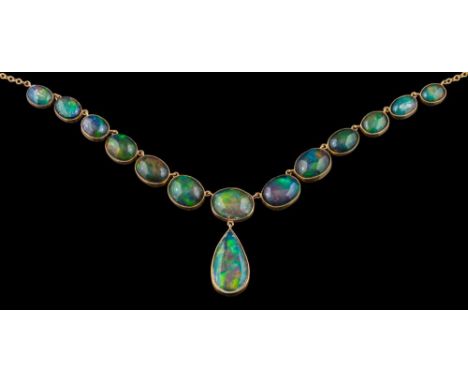 An opal mounted necklace: of graduated oval opal doublets and opals with black painted backs and suspending a single pear-sha