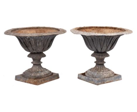 A pair of lead garden urns: of campana form, raised on a fluted and knopped stem and square plinth base, 47cm. diameter, 39cm