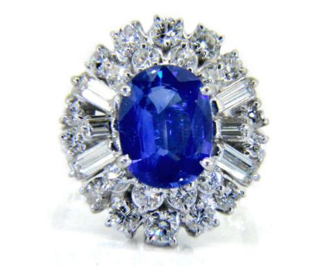 A sapphire and diamond cocktail cluster ring: circa 1950 with central oval blue sapphire 10.7mm long x 8.1mm wide, approximat