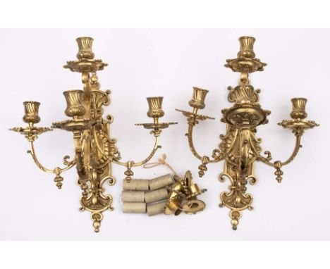 A pair of Victorian brass four-light wall sconces: with cartouche-shaped and scroll decorated backplate with three swept and 