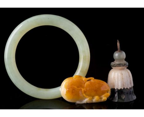 A mixed lot of Chinese jade: comprising a celadon and russet pendant in the form of two peaches, 5cm; a celadon bangle, 8.5cm