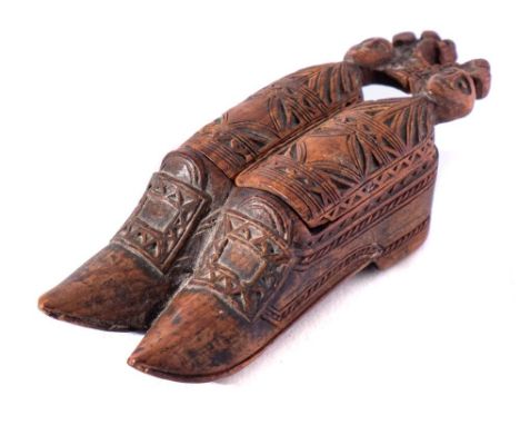An 18th Century treen novelty snuff box: in the form of a pair of shoes, with carved geometric decoration, 8cm. long.
