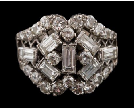 A diamond mounted cocktail cluster ring: with a symmetrical cluster of brilliant and baguette-cut diamonds over a latticework