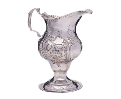 A George III silver embossed pedestal cream jug, maker's mark worn, London, 1782: of helmet-shaped outline with embossed flor