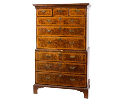 An early 18th Century walnut and cross and feather banded tallboy:, the upper part with a moulded cornice, containing three s