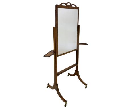 Early 19th century mahogany cheval dressing mirror, ribbon shaped pediment, the rectangular plate on an adjustable sliding sa