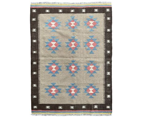 Kilim rug, light brown ground field decorated with geometric star motifs, dark brown border band and multi-coloured end bands