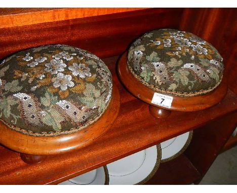 A pair of Victorian mahogany based foot stools with beaded tapestry covers