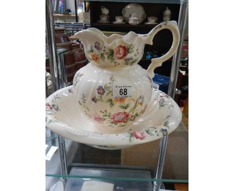 A floral pottery wash basin and jug