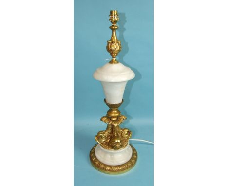 An impressive gilt brass and alabaster table lamp in the form of an urn, supported on stylised dolphins raised on an alabaste