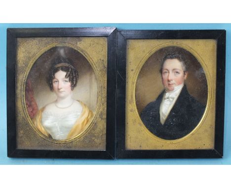 A pair of 19th century miniature portraits of a gentleman wearing a blue coat and white stock and his wife wearing a white dr