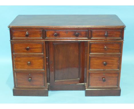 A Late-Victorian mahogany knee-hole dressing table having an arrangement of three frieze drawers and six pedestal drawers enc