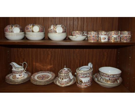 A 19th century English porcelain part tea service decorated with gilt and coloured panels of flowers and birds and a central 