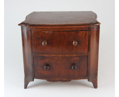 A George III mahogany Hepplewhite style miniature chest of two drawers fitted with turned wooden knob handles, raised on poin