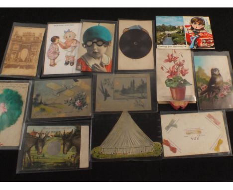 Fifty six various novelty, hold to light and topographical postcards