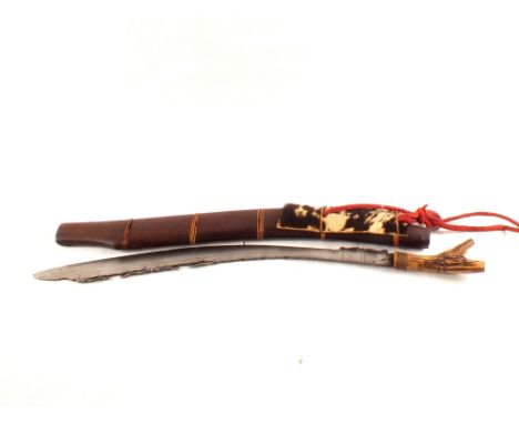 A Dyak Headhunters sword Mandau with carved wooden scabbard