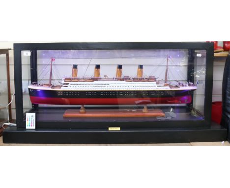 A scratch-built model of the RMS Titanic, painted wood hull, in glazed wood cabinet with remote control lighting, cabinet len