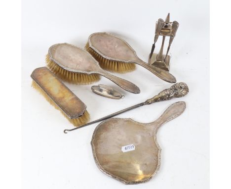 A 4-piece silver-backed dressing table brush and mirror set, nail buffer, silver-handled button hook, and a silver-clad manic