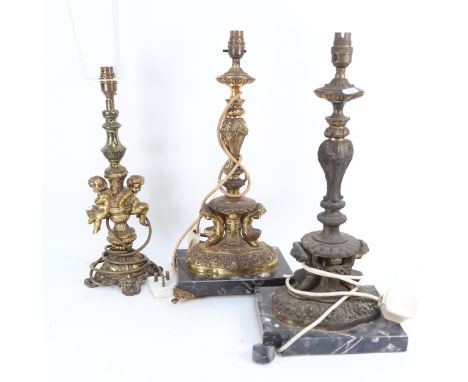 A pair of embossed gilt-metal table lamps on marble plinths, 49cm, and a brass table lamp with cherub figures 