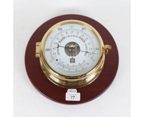 A good quality modern brass-cased ship's barometer/thermometer, by Sewills, mounted on mahogany plaque, case diameter 16cm 