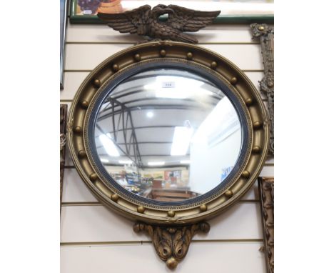 A reproduction Regency style circular convex wall mirror, with eagle pediment, overall height 75cm 