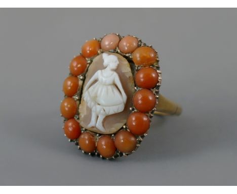 Georgian oval carved cameo ring, the central panel depicting a young dancing lady, surrounded by fourteen cabouchon corals, r