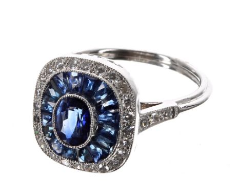 Platinum sapphire and diamond ring, set with an oval central sapphire, 0.62ct approx, a halo setting of calibre-cut sapphires