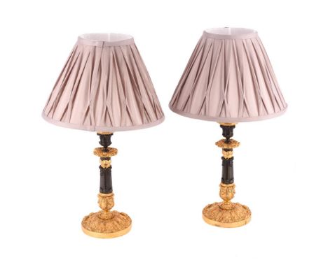 A PAIR OF GILT AND PATINATED BRONZE CANDLESTICKS  19TH CENTURY AND LATER CONVERTED TO ELECTRICITY  Each with fluted tapering 